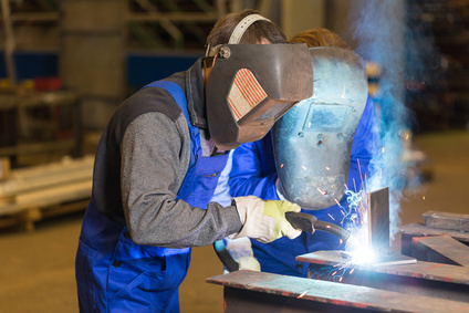 Two steel construction workers welding metal